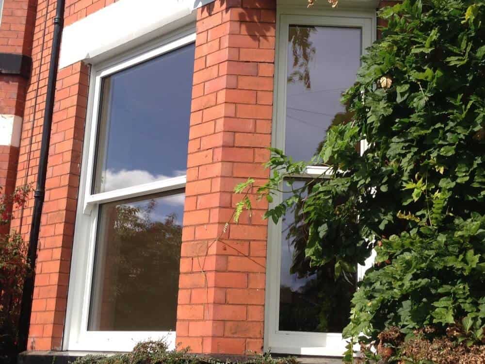 White Accoya wood sash bay windows against red brick