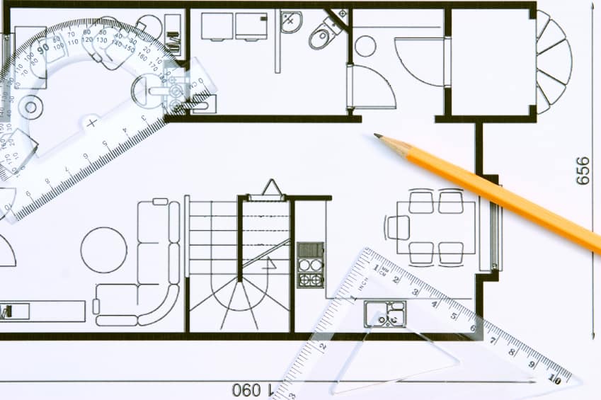 A floor plan with protractor, pencil and setsquare on top of it.
