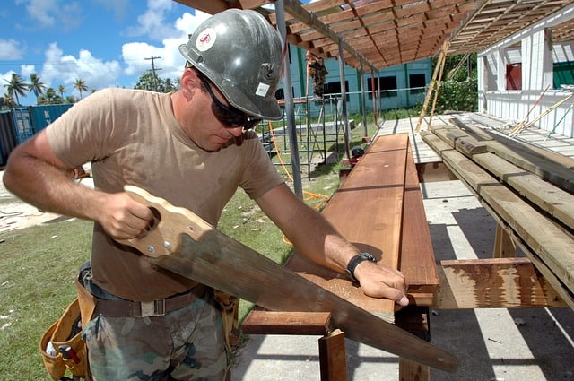 Worker sawing wood